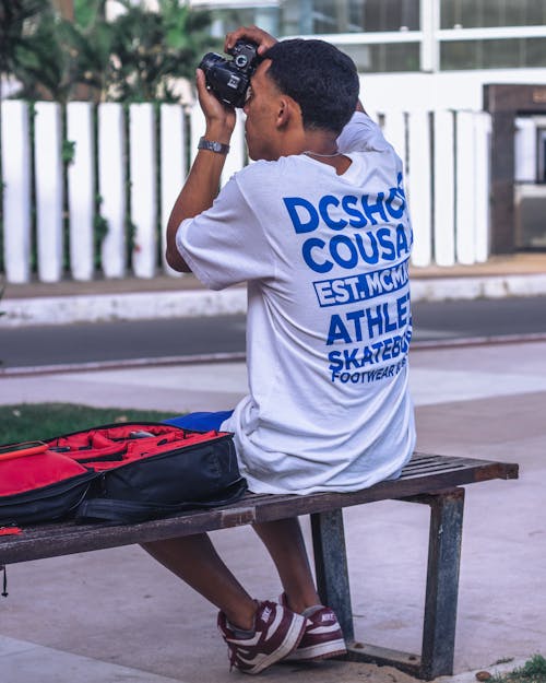 Man Sitting on a Bench and Taking a Picture 