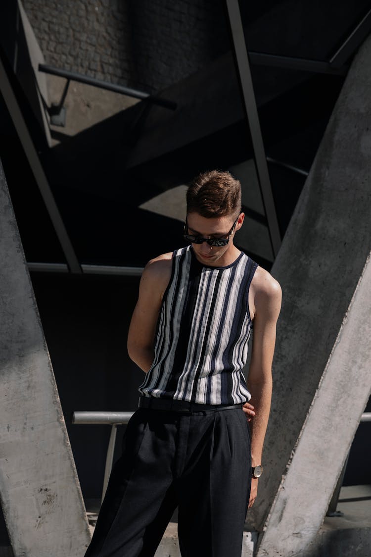 Stylish Man In Sunglasses Posing Near Bridge Pillars