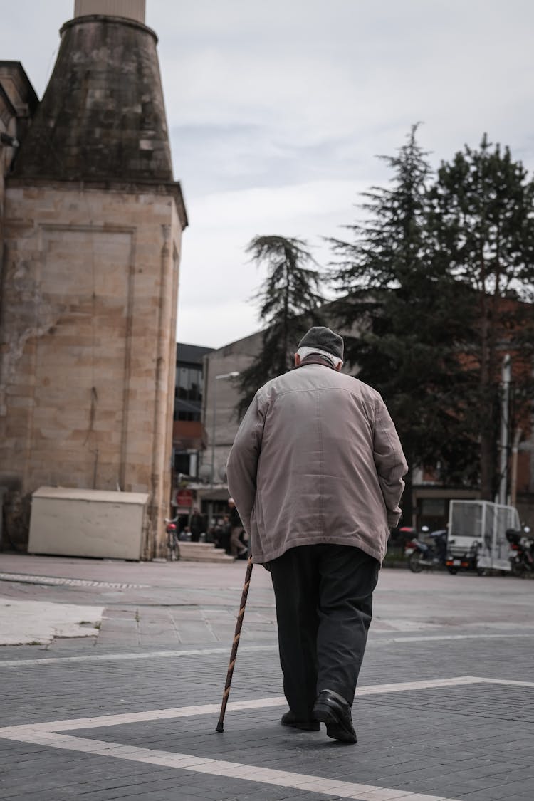 Back View Of A Man Walking With A Cane 