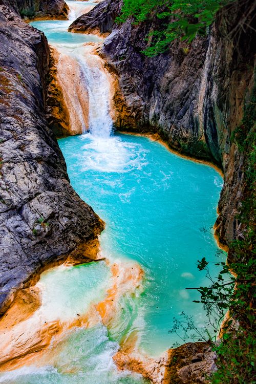 Free Vivid turquoise water cascading through a rocky canyon, showcasing nature's beauty. Stock Photo