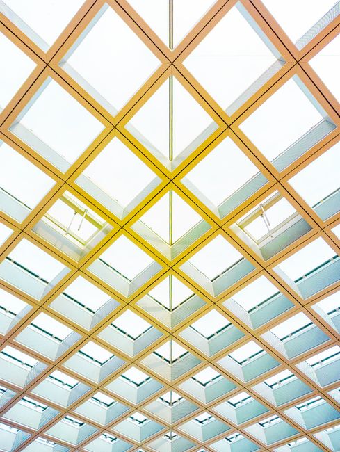 A modern geometric ceiling design with natural light streaming through in Venice, Italy.