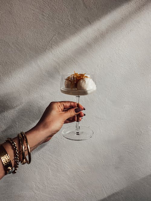 Woman Holding a Glass with Dessert 