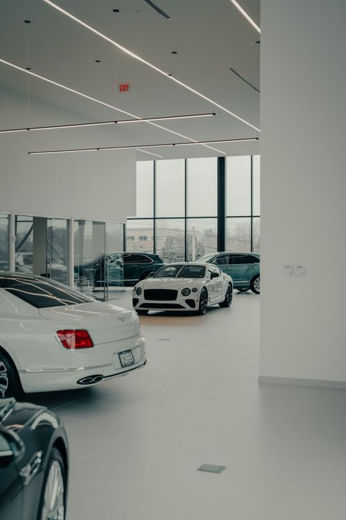 Free Sleek Bentley cars showcased in a contemporary indoor dealership space, emphasizing luxury and design. Stock Photo
