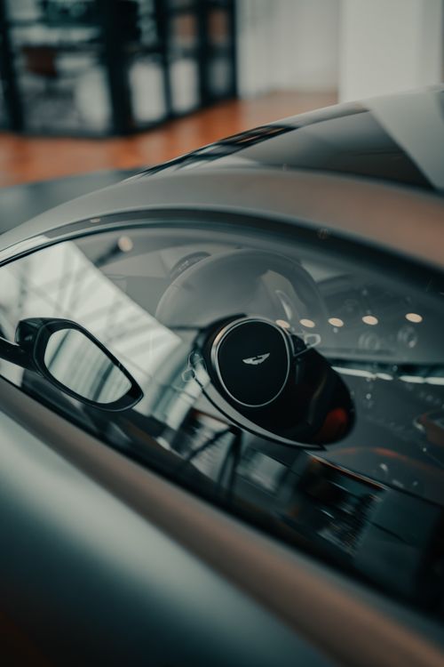 Free A detailed close-up of a luxury car's steering wheel through the window. Stock Photo