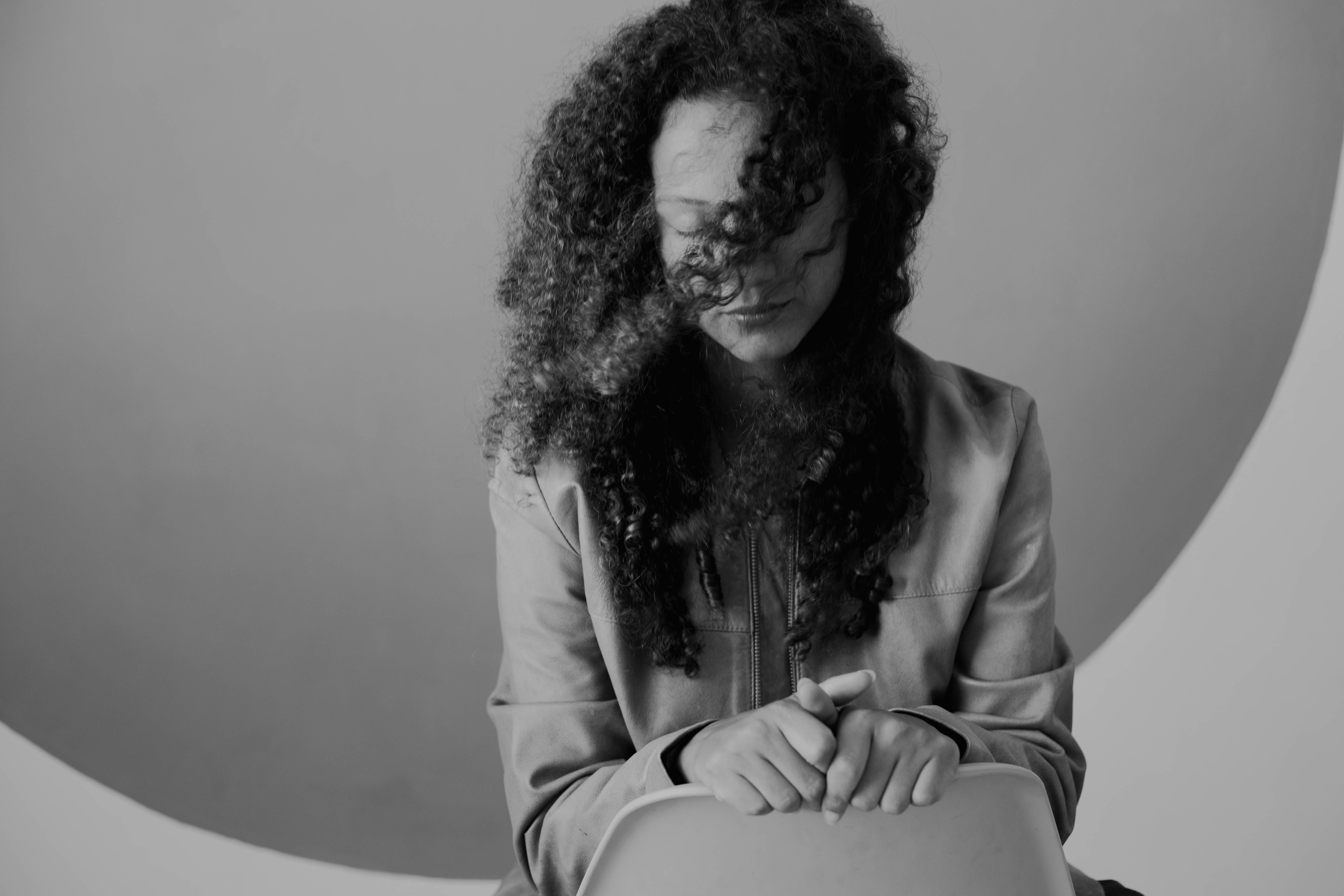 Woman with Curly Hair Posing in Black and White · Free Stock Photo