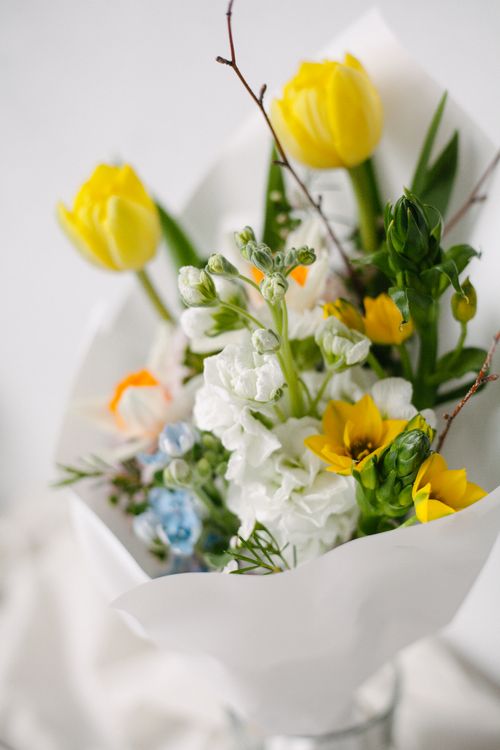Free Elegant bouquet with yellow tulips and white blossoms in soft lighting. Stock Photo