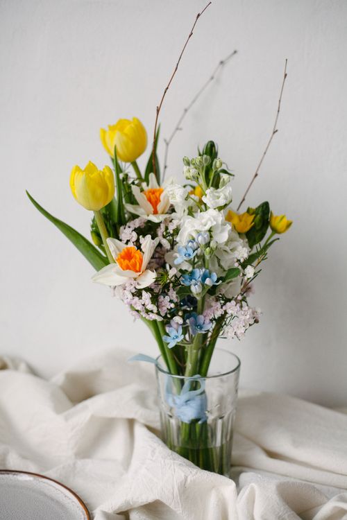 Free Beautiful spring bouquet featuring tulips, daffodils, and seasonal flowers in a glass vase. Stock Photo
