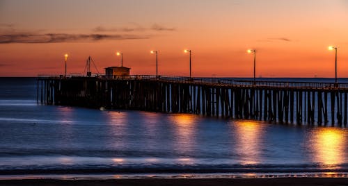 木制码头在海边与日落期间的灯柱