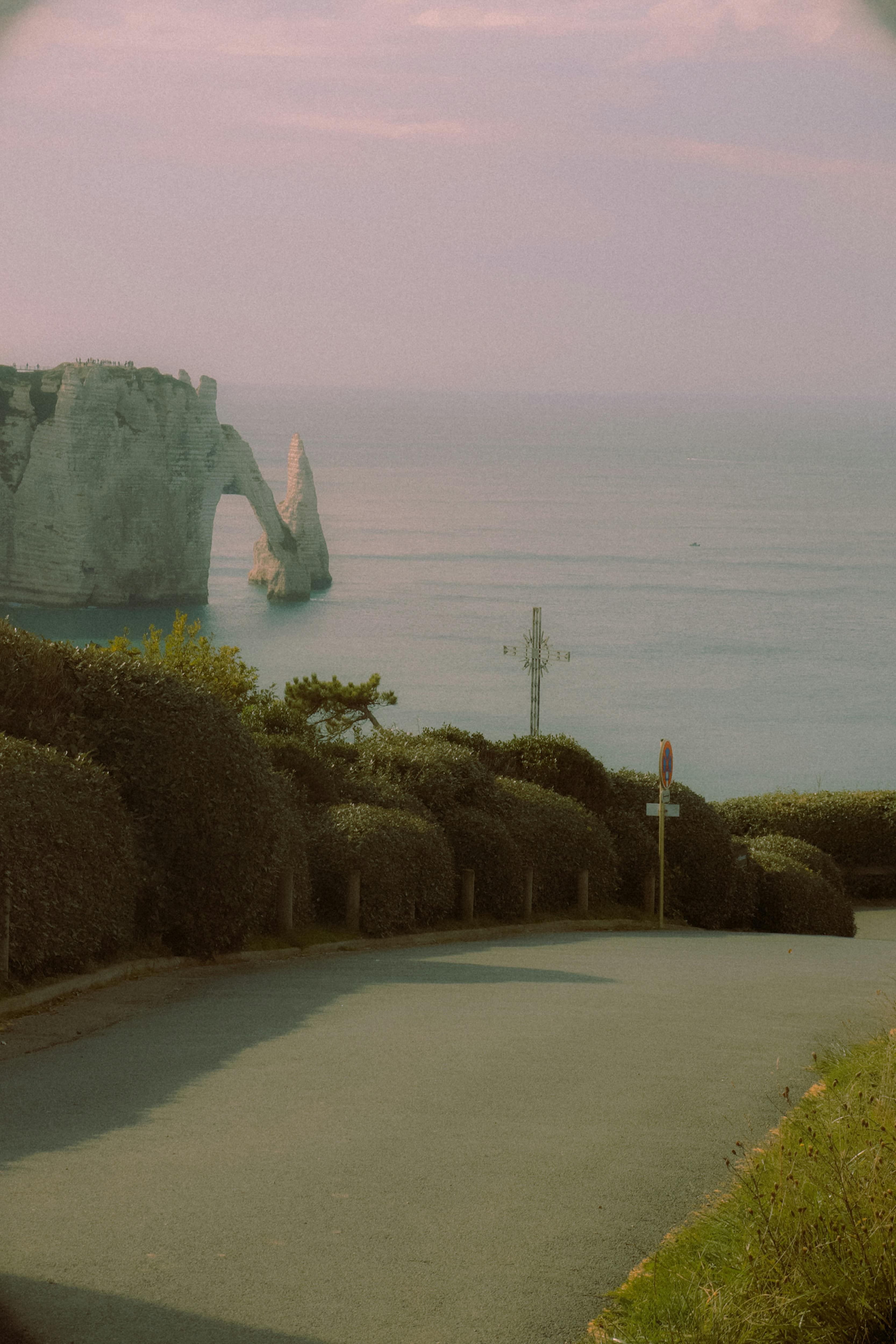 A road leading to the ocean with a view of the cliffs