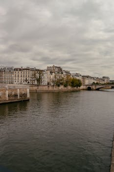 Peaceful morning view over the Seine River in Paris, showcasing historic buildings and tranquil waters.