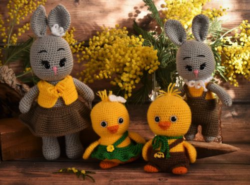 Free Charming handmade knitted rabbit and duck toys set against a backdrop of vibrant wildflowers. Stock Photo