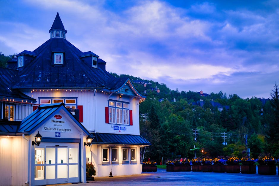 Beautiful evening view of Chalet des Voyageurs in Mont Tremblant with vibrant skies and lush greenery.