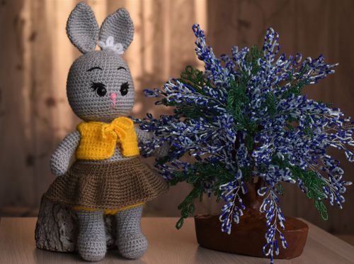 Free Adorable handmade crochet bunny toy next to a decorative plant in a cozy setting. Stock Photo