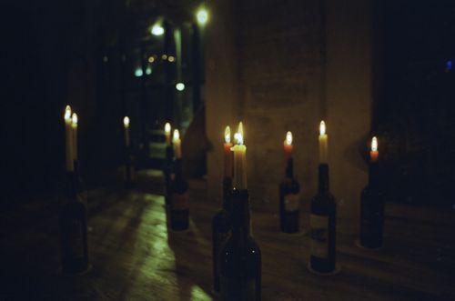 Free A row of candles in wine bottles creates a warm, intimate atmosphere. Stock Photo
