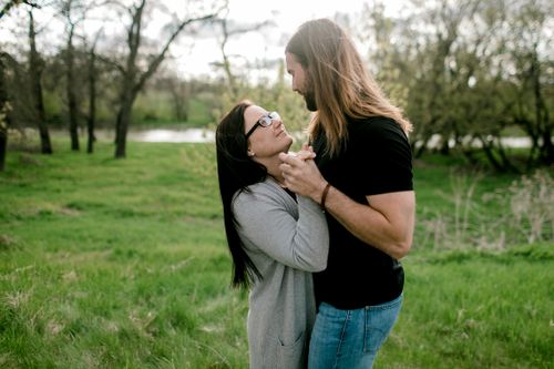 Free A loving couple embraces and dances in a lush green park, symbolizing romance. Stock Photo