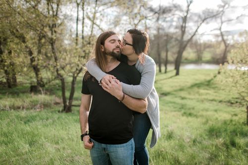 Free Couple sharing a tender moment in a lush, sunny park, showcasing affection and tranquility. Stock Photo