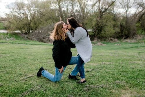 Free Heartfelt proposal in a lush green park setting, capturing a genuine moment of love. Stock Photo