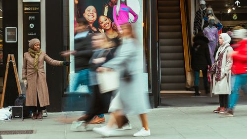 Free Dynamic city street scene with people in motion near escalators. Stock Photo