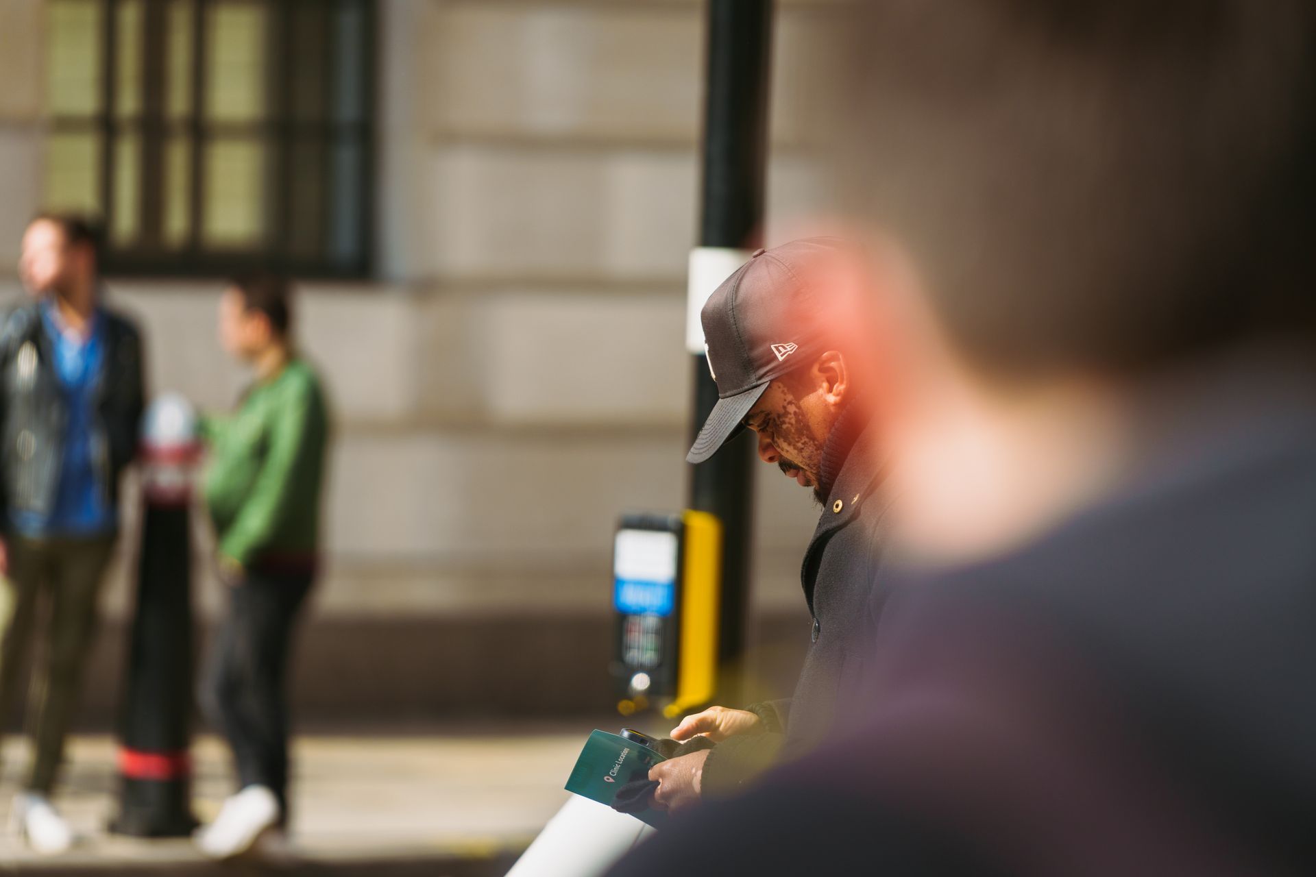 An urban snapshot capturing a man in a cap amidst a bustling city street environment.