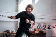 Bearded martial artist demonstrates powerful brick-breaking technique.