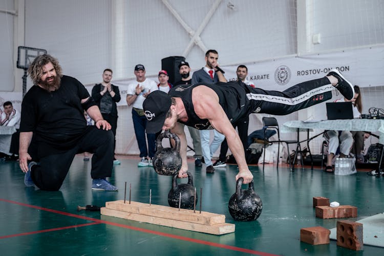 A Man Doing A Performance With Weights 