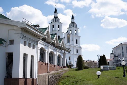 Free Stunning white church with twin bell towers against a vibrant blue sky and clouds. Stock Photo