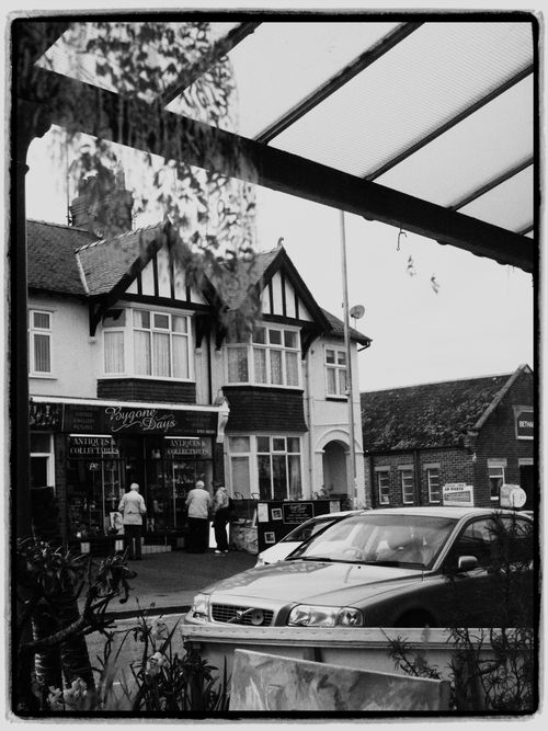 Free A black and white photo of a vintage street with classic architecture and a car parked in front. Stock Photo
