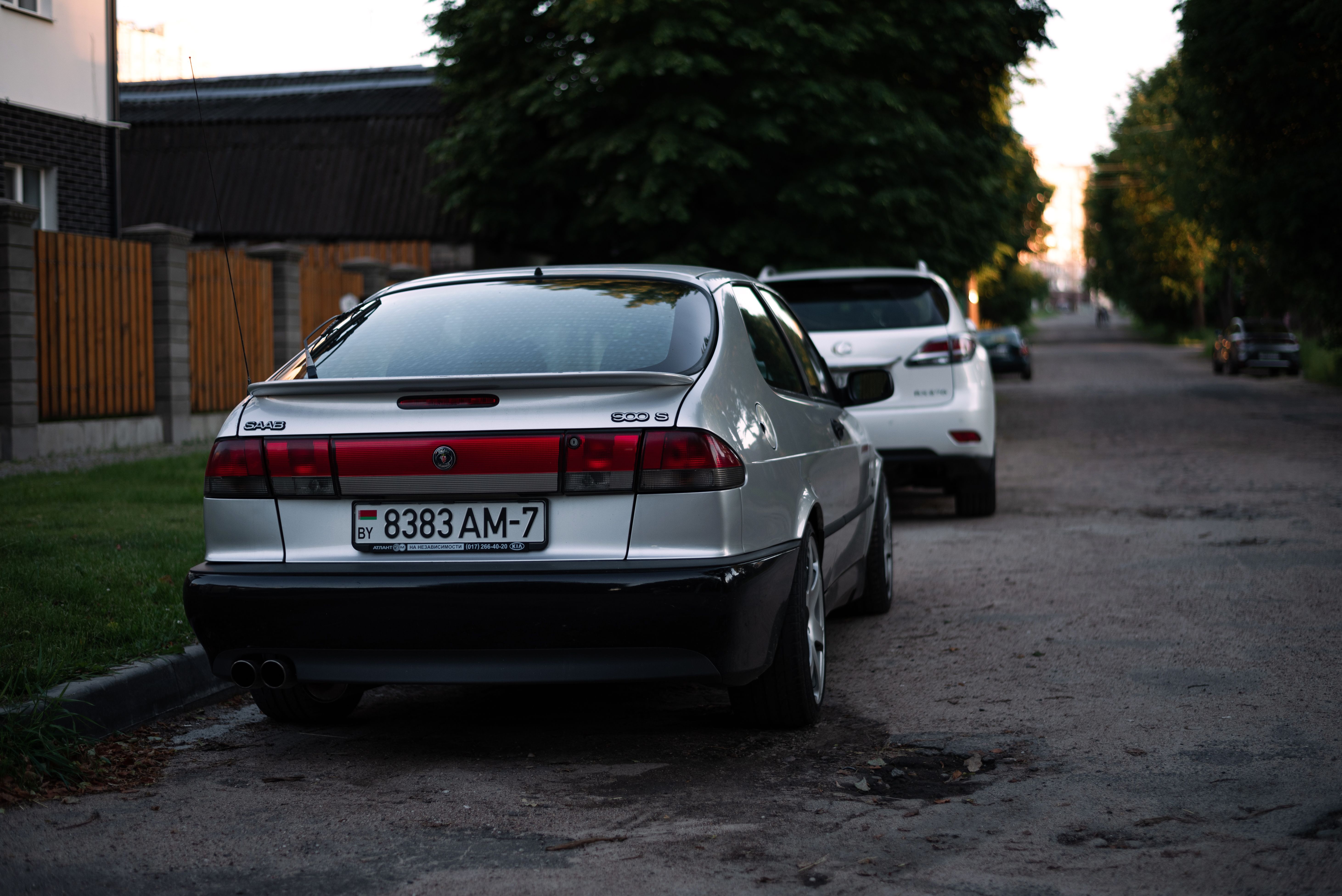 Rear view of a parked car on a quiet street at dusk with soft evening lighting.