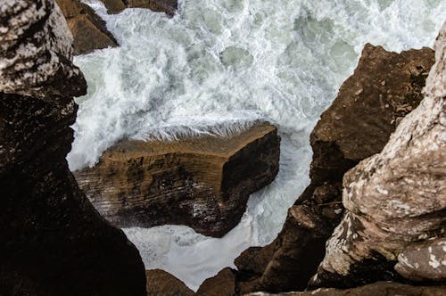 Top View of Foamy Waves Splashing on a Rocky Shore 