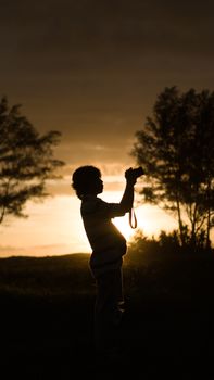 Silhouette of a photographer capturing the sunset light in Bengkulu, Indonesia.