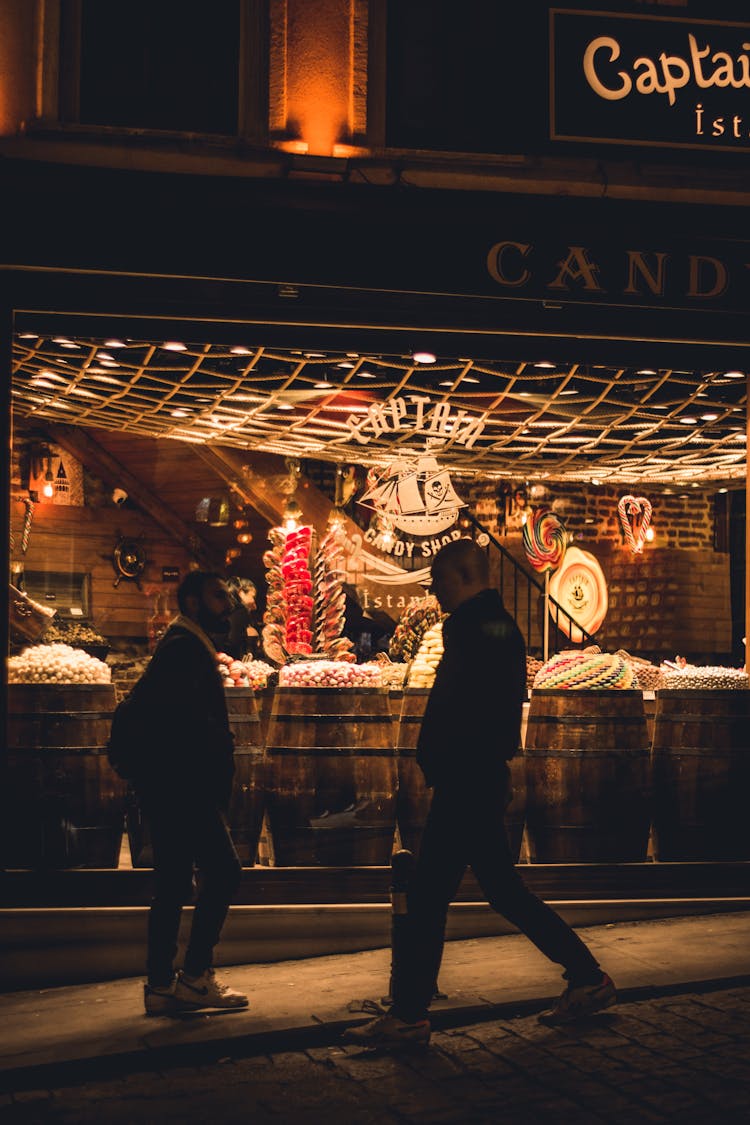 Men In Front Of Store Window At Night