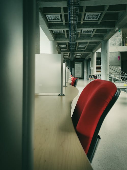 Empty Desks with Red Chairs in a Modern Interior 