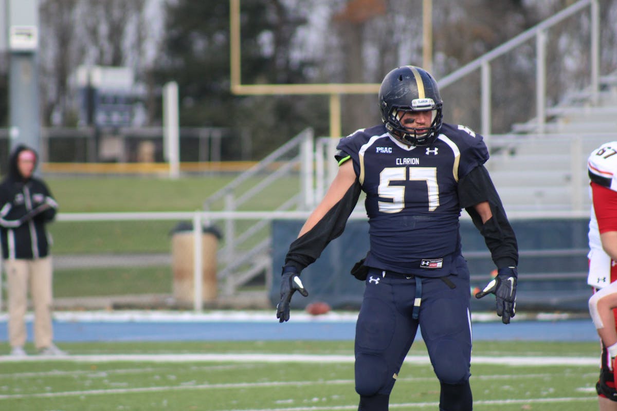 Football kicker striking the ball on a field goal attempt with holder in place