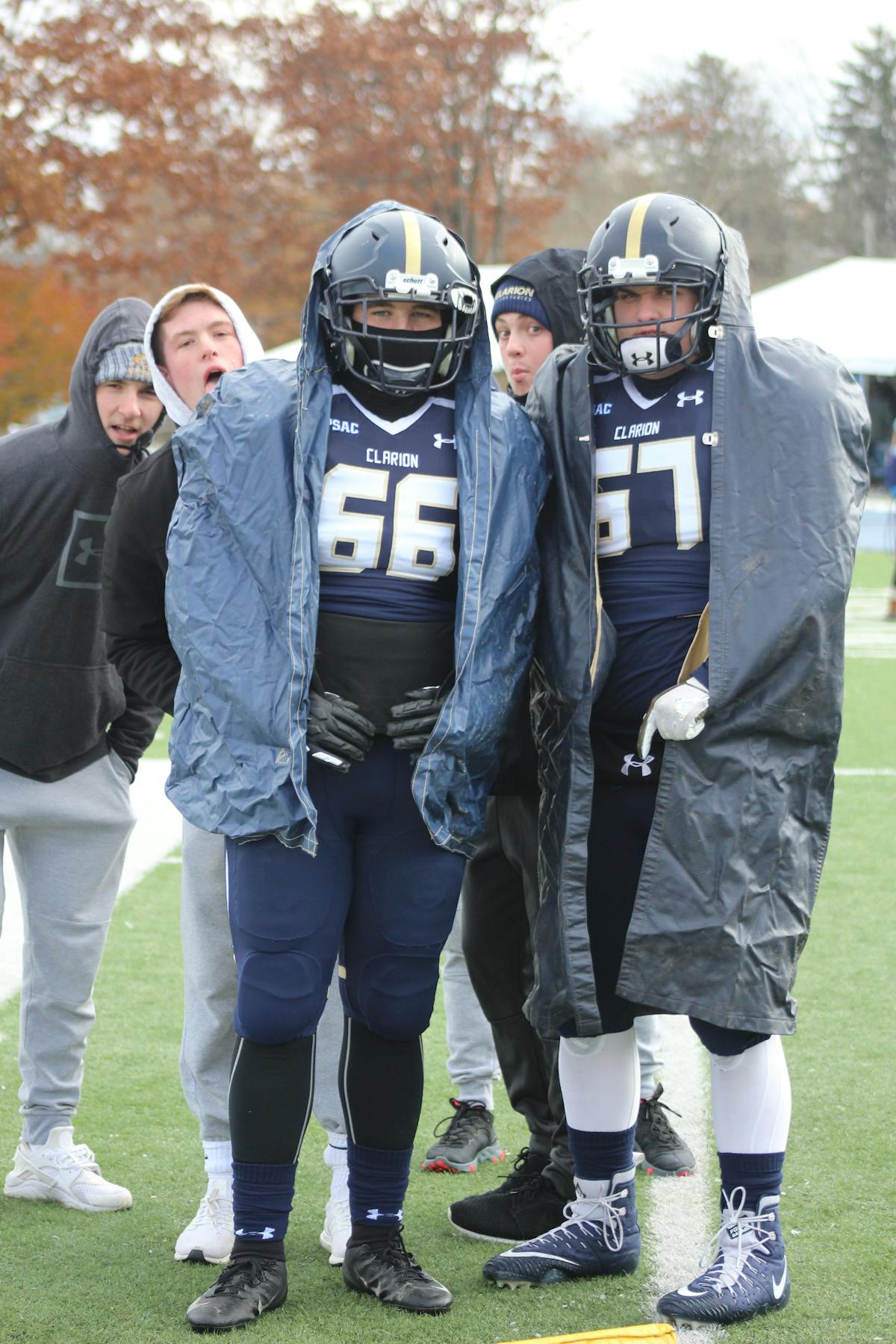 Football player tackled while carrying the ball demonstrating physical defense