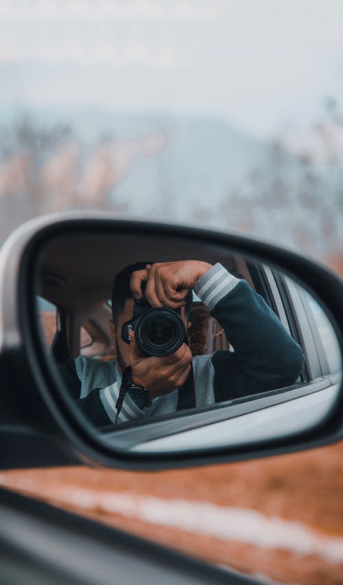 Man with Camera Reflection in Car Mirror