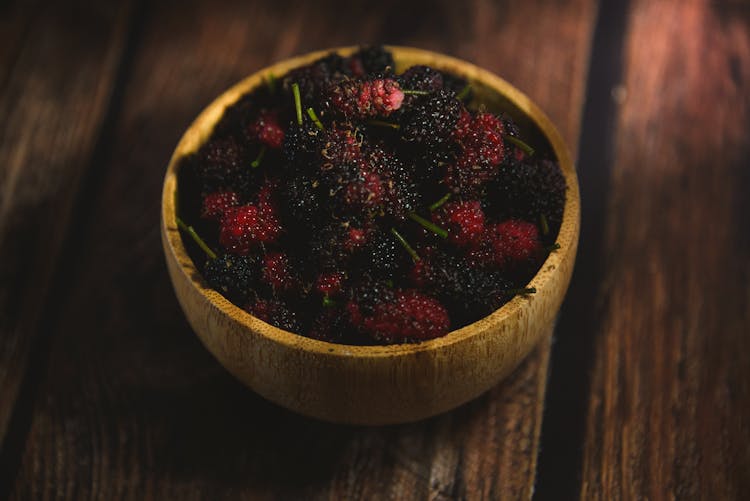 Close-up Of A Bowl With Berries Standing On A Wooden Surface