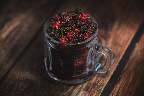 Close-up of a Glass with Berries Standing on a Wooden Surface 