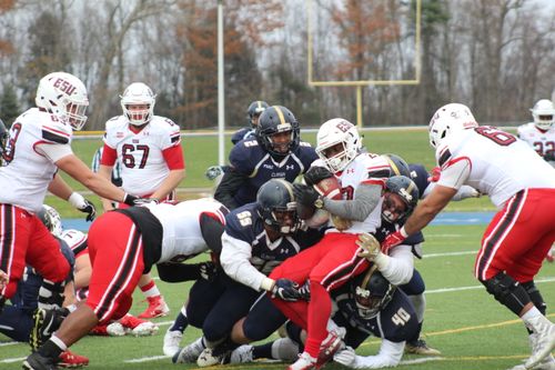 Free College football players in action during an intense tackle on the field showcasing teamwork and competition. Stock Photo