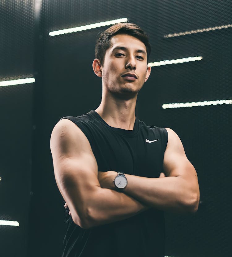 Young Man In A Sports Tank Top Standing With Arms Crossed 