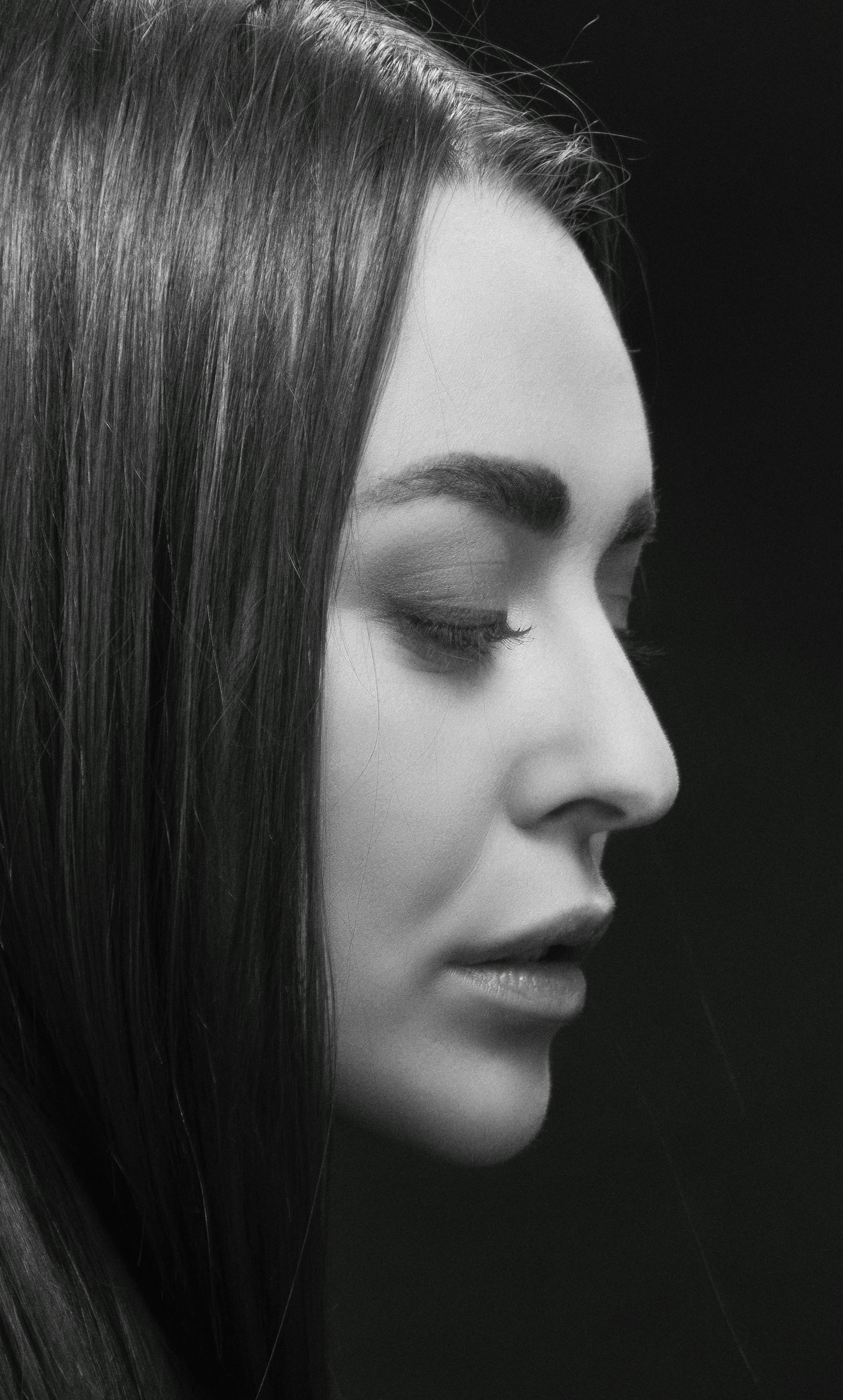 Captivating black and white portrait of a brunette woman in profile view.