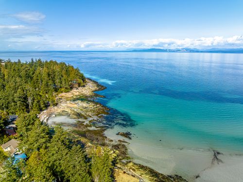 Free Stunning aerial view of Hornby Island's coastline in British Columbia, Canada, showcasing clear blue waters and lush forests. Stock Photo