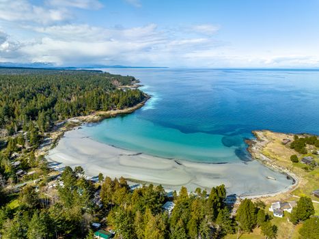 Stunning aerial view of Hornby Island's coastline in BC, featuring lush forests and serene blue waters.