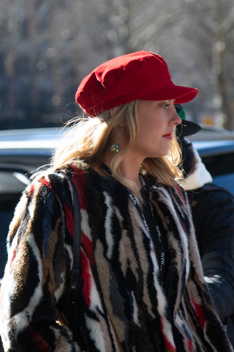 Stylish woman in fur coat and red cap in New York winter