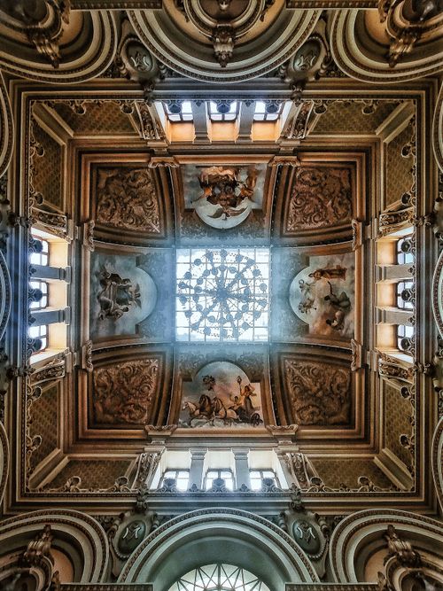 Free View of a detailed ornate church ceiling featuring frescoes and a central skylight. Stock Photo