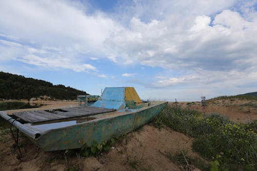 Free Clouds over a Deteriorating Boat Abandoned on a Beach Stock Photo