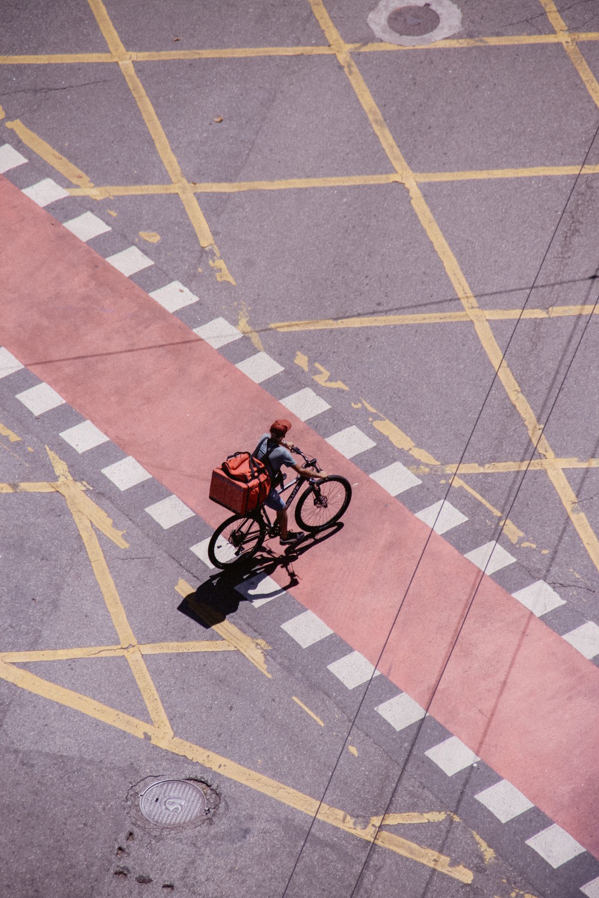 Bicycle delivery courier transporting a parcel through an urban street