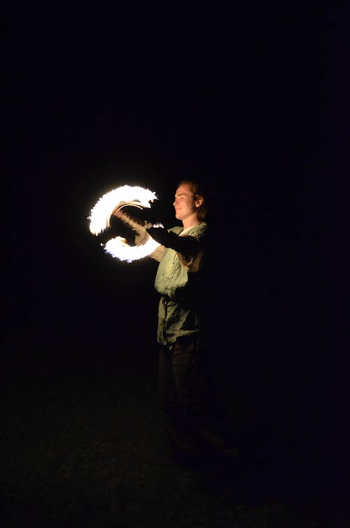 Man Standing While Playing With Fire At Night
