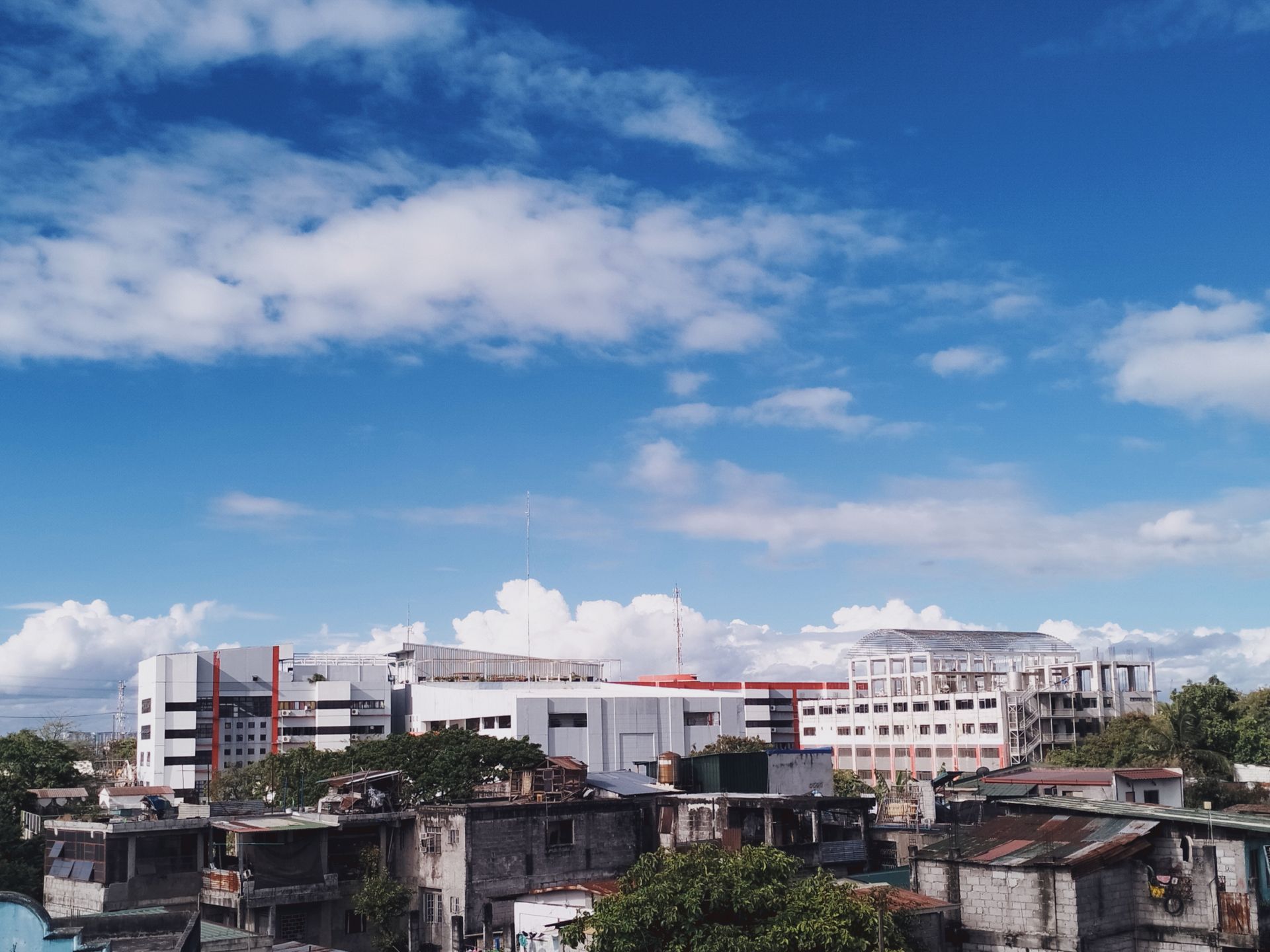 Skyline of Taguig, Manila showcasing modern buildings against a bright blue sky.