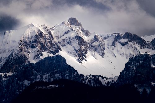 Free Majestic snow-covered mountains under a moody sky in Lausanne, Switzerland. Stock Photo