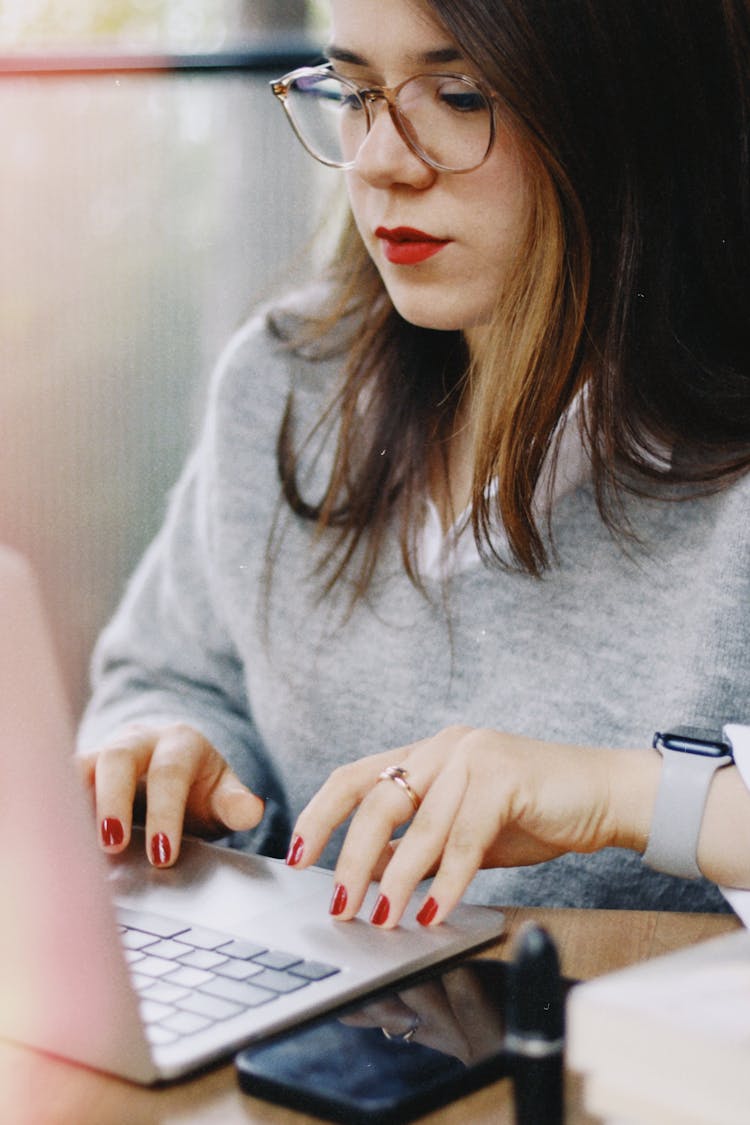 Closeup Of A Woman With Red Lipstick And Manicure, Typing On A Laptop